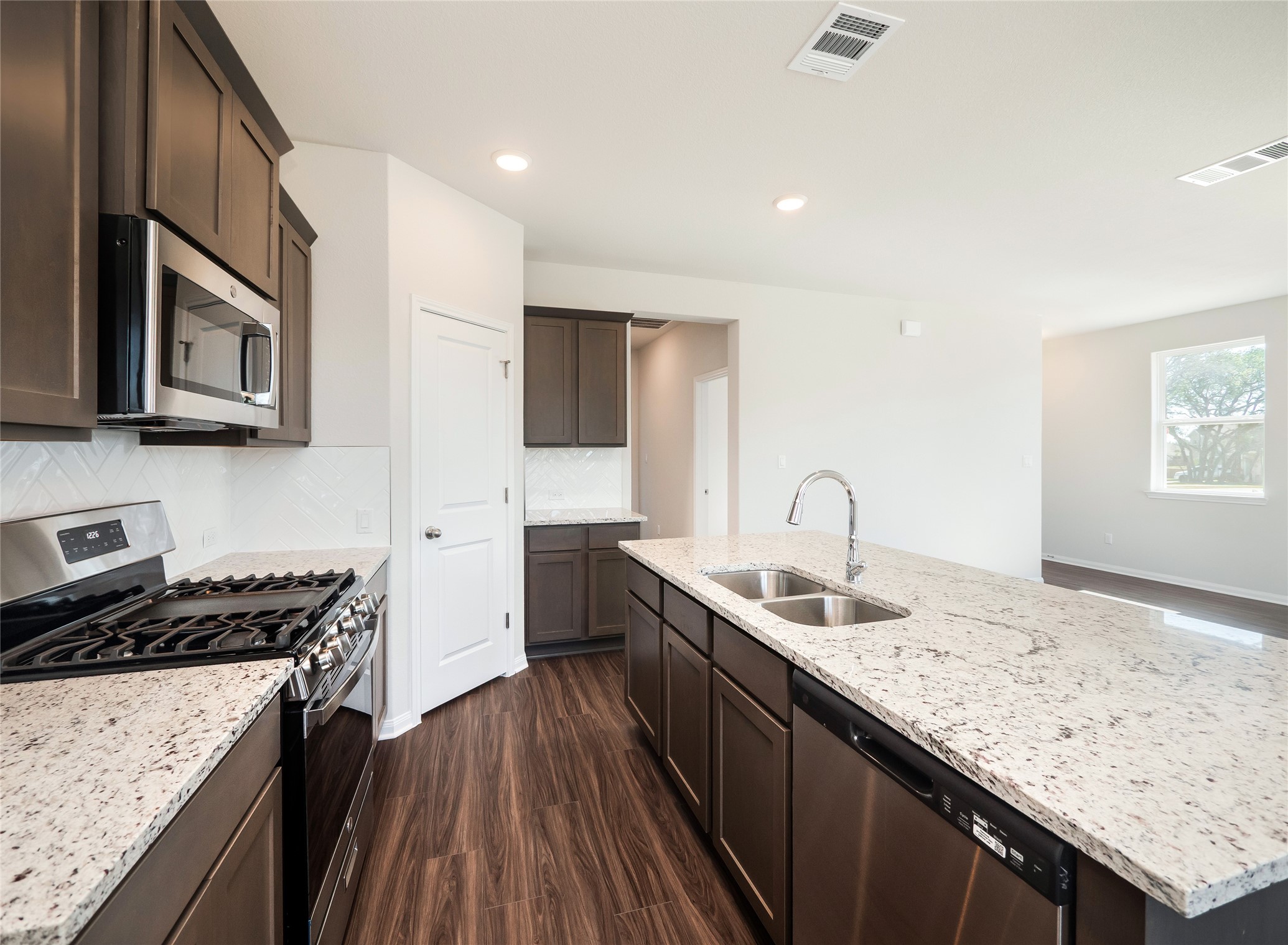 181 Soldier Street Kyle, TX 78640 - Photo 9 of 37 a kitchen with granite countertop sink stainless steel appliances and cabinets