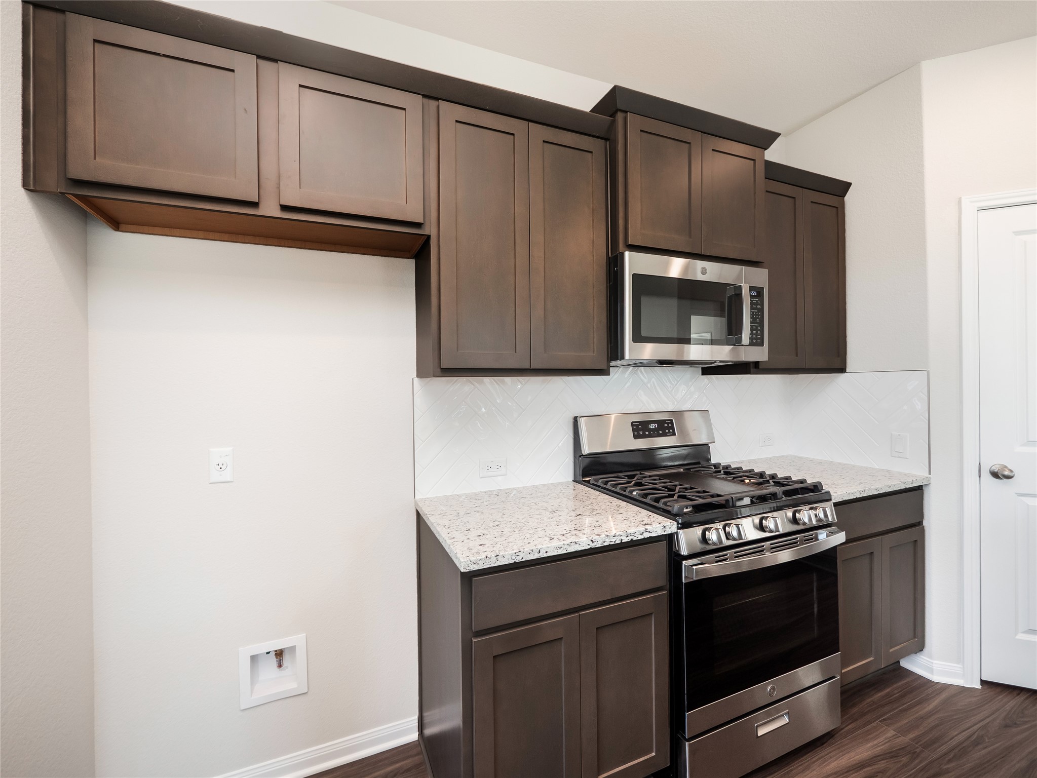 181 Soldier Street Kyle, TX 78640 - Photo 10 of 37 a kitchen with granite countertop cabinets stainless steel appliances and wooden floor