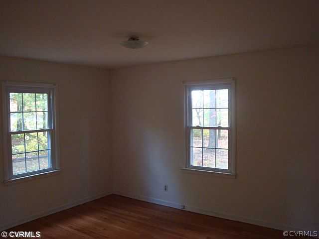 223 Evans Mill Road Dillwyn, VA 23936 - Photo 8 of 11 an empty room with wooden floor and windows