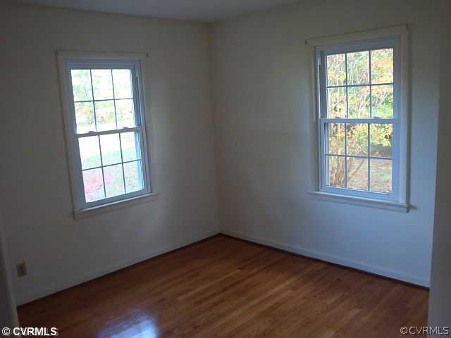 223 Evans Mill Road Dillwyn, VA 23936 - Photo 9 of 11 an empty room with wooden floor and windows