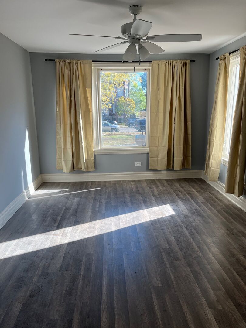 7438 South Champlain Avenue Chicago, IL 60619 - Photo 12 of 41 an empty room with wooden floor and windows