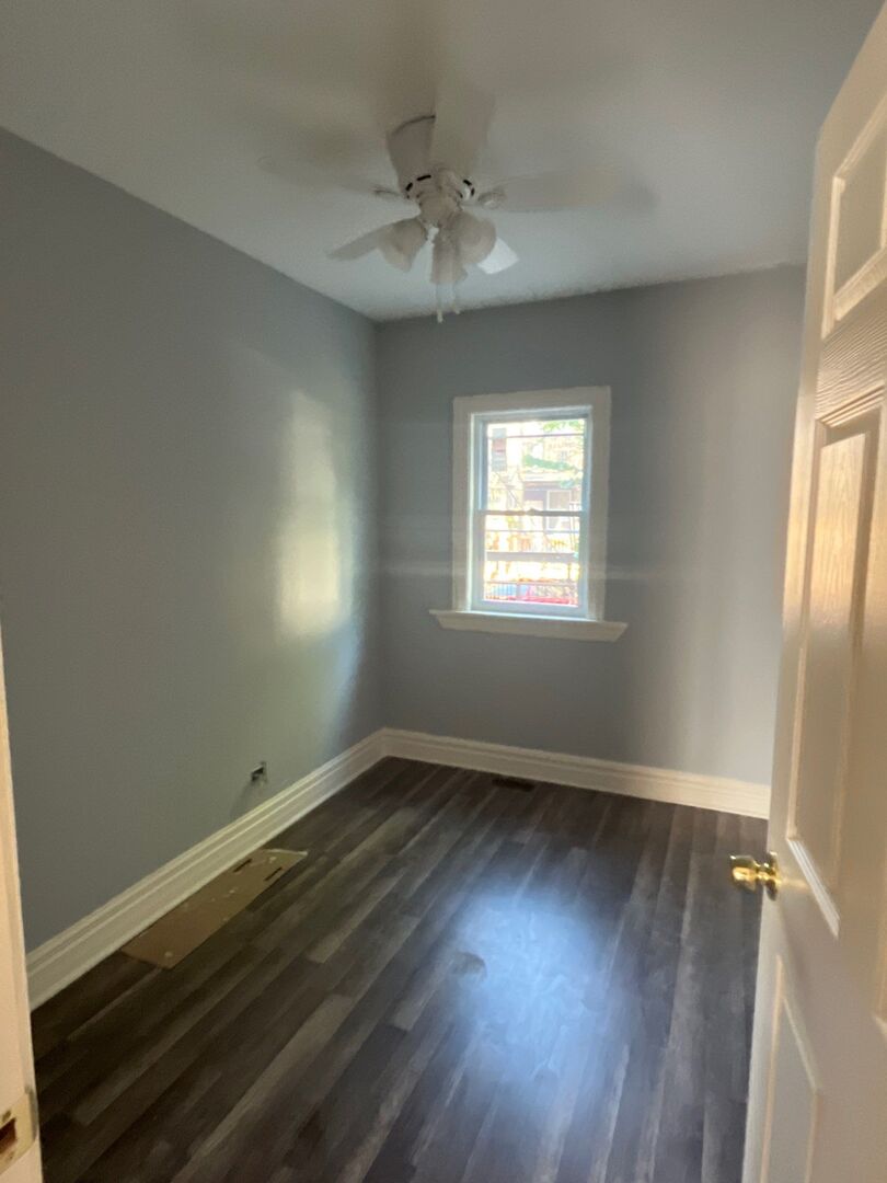 7438 South Champlain Avenue Chicago, IL 60619 - Photo 14 of 41 a view of an empty room with wooden floor and a window