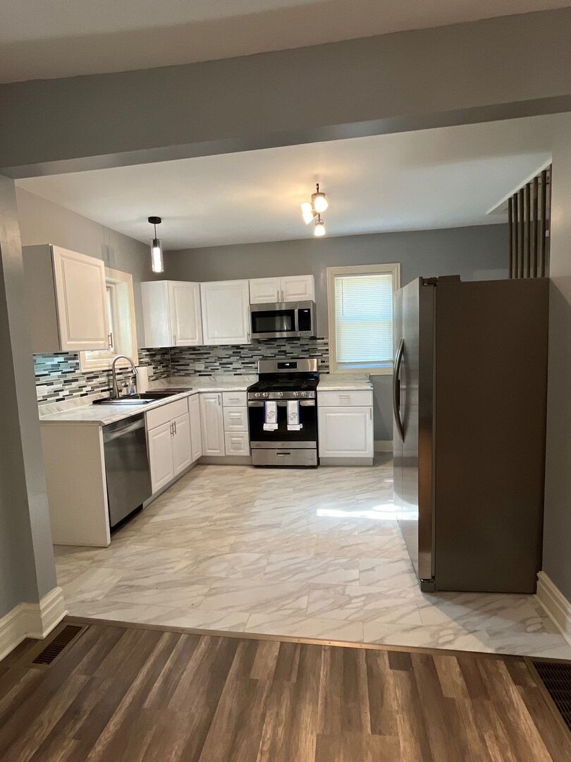 7438 South Champlain Avenue Chicago, IL 60619 - Photo 16 of 41 a large kitchen with cabinets and stainless steel appliances