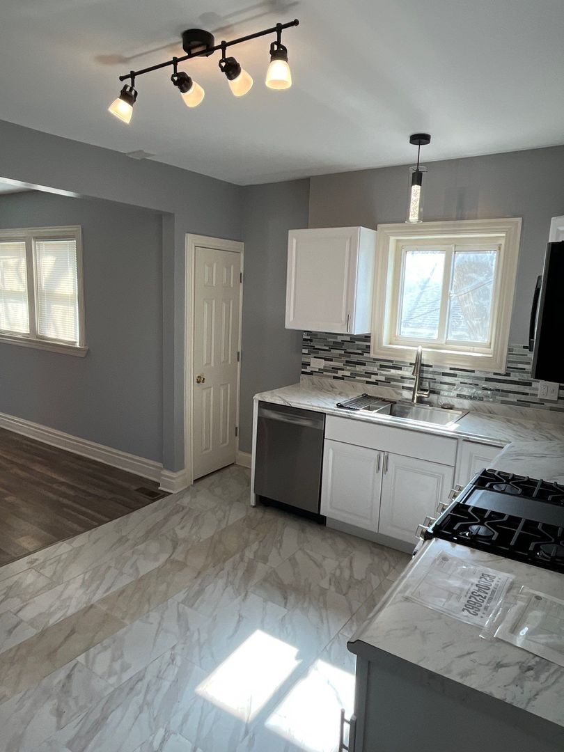 7438 South Champlain Avenue Chicago, IL 60619 - Photo 17 of 41 a kitchen with a stove a sink and a window