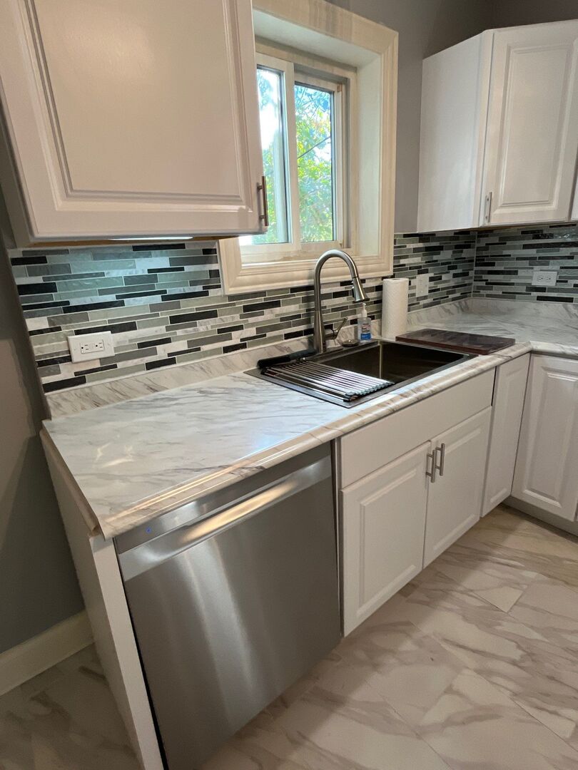 7438 South Champlain Avenue Chicago, IL 60619 - Photo 18 of 41 a kitchen with granite countertop a sink a stove and cabinets