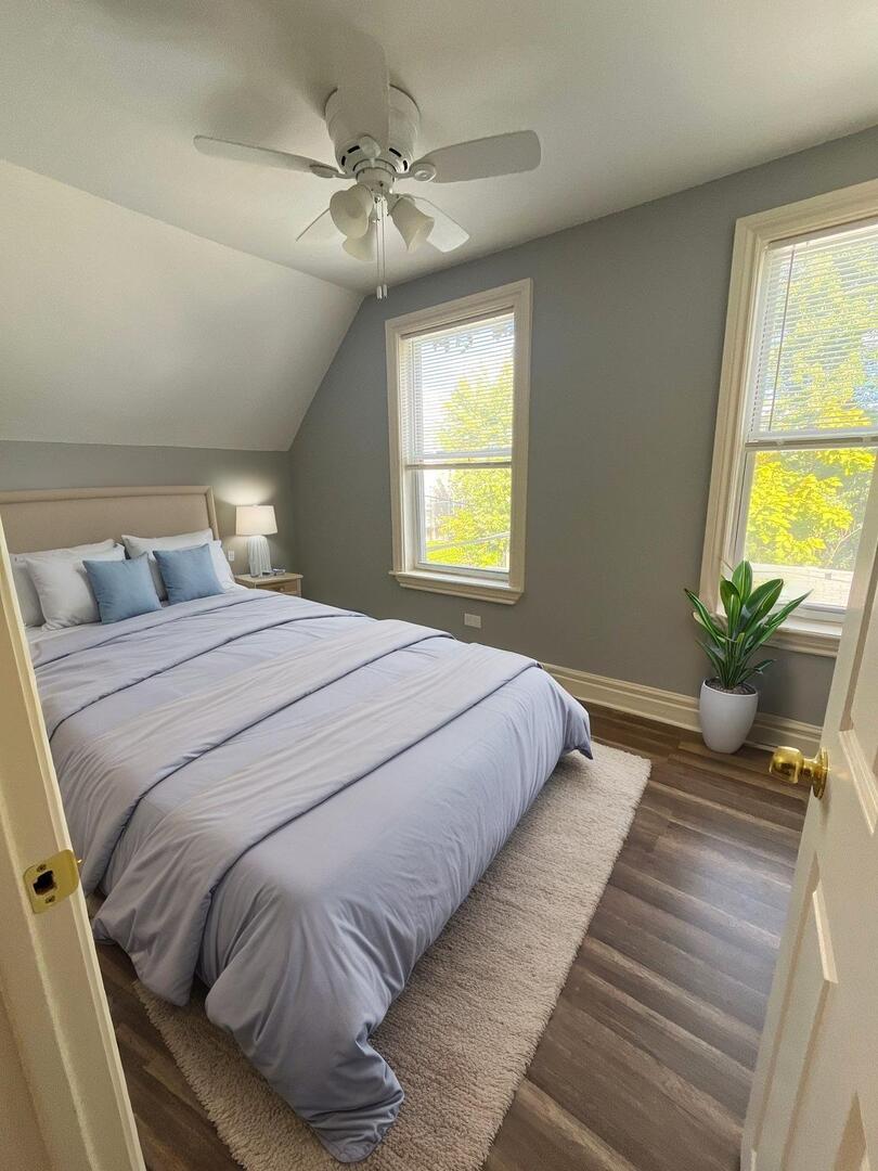 7438 South Champlain Avenue Chicago, IL 60619 - Photo 31 of 41 a bedroom with a large bed and a chandelier