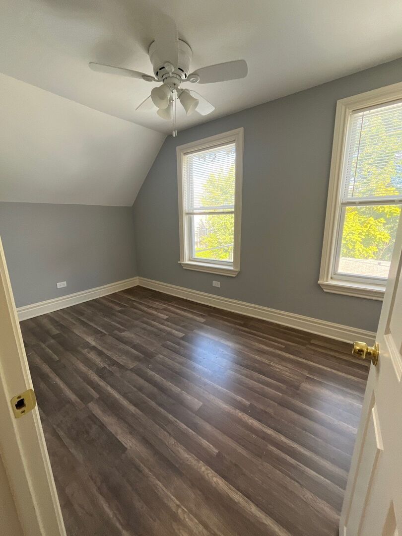 7438 South Champlain Avenue Chicago, IL 60619 - Photo 32 of 41 a view of an empty room with wooden floor and a window