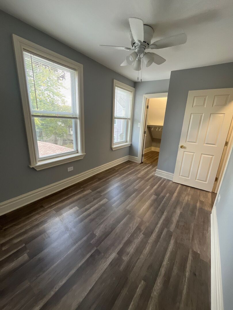 7438 South Champlain Avenue Chicago, IL 60619 - Photo 33 of 41 a view of an empty room with wooden floor and a window