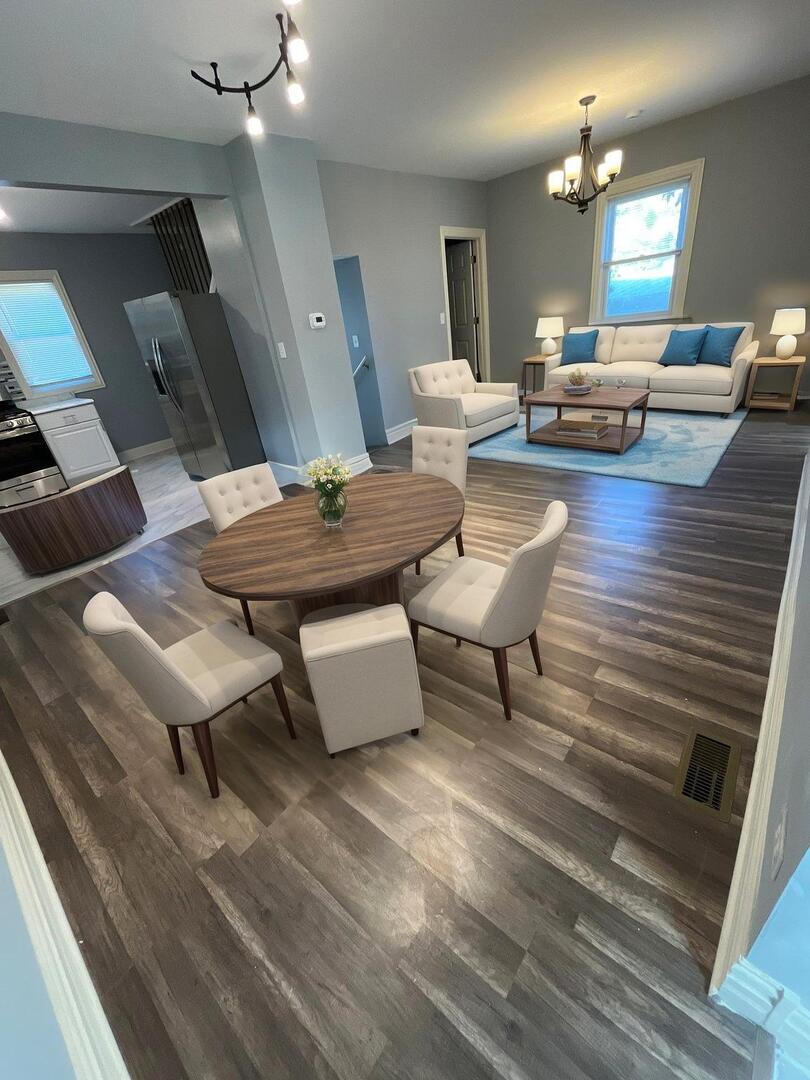 7438 South Champlain Avenue Chicago, IL 60619 - Photo 6 of 41 a living room with couches and kitchen view with wooden floor