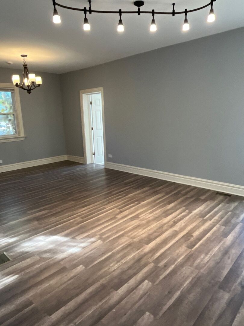 7438 South Champlain Avenue Chicago, IL 60619 - Photo 8 of 41 a view of an empty room with window and wooden floor