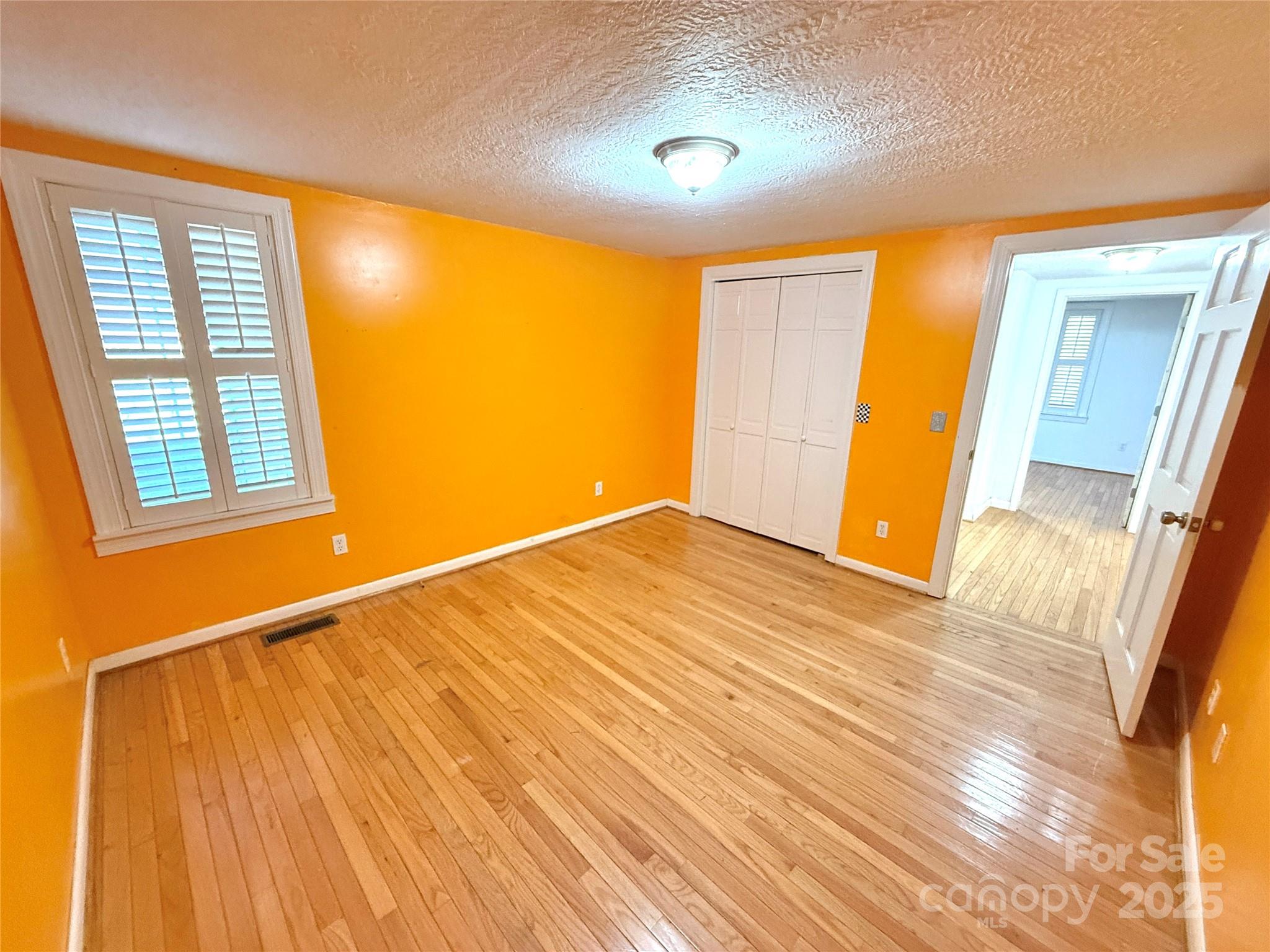 718 Bald Mountain Road Burnsville, NC 28714 - Photo 15 of 37 a view of an empty room with wooden floor and a window