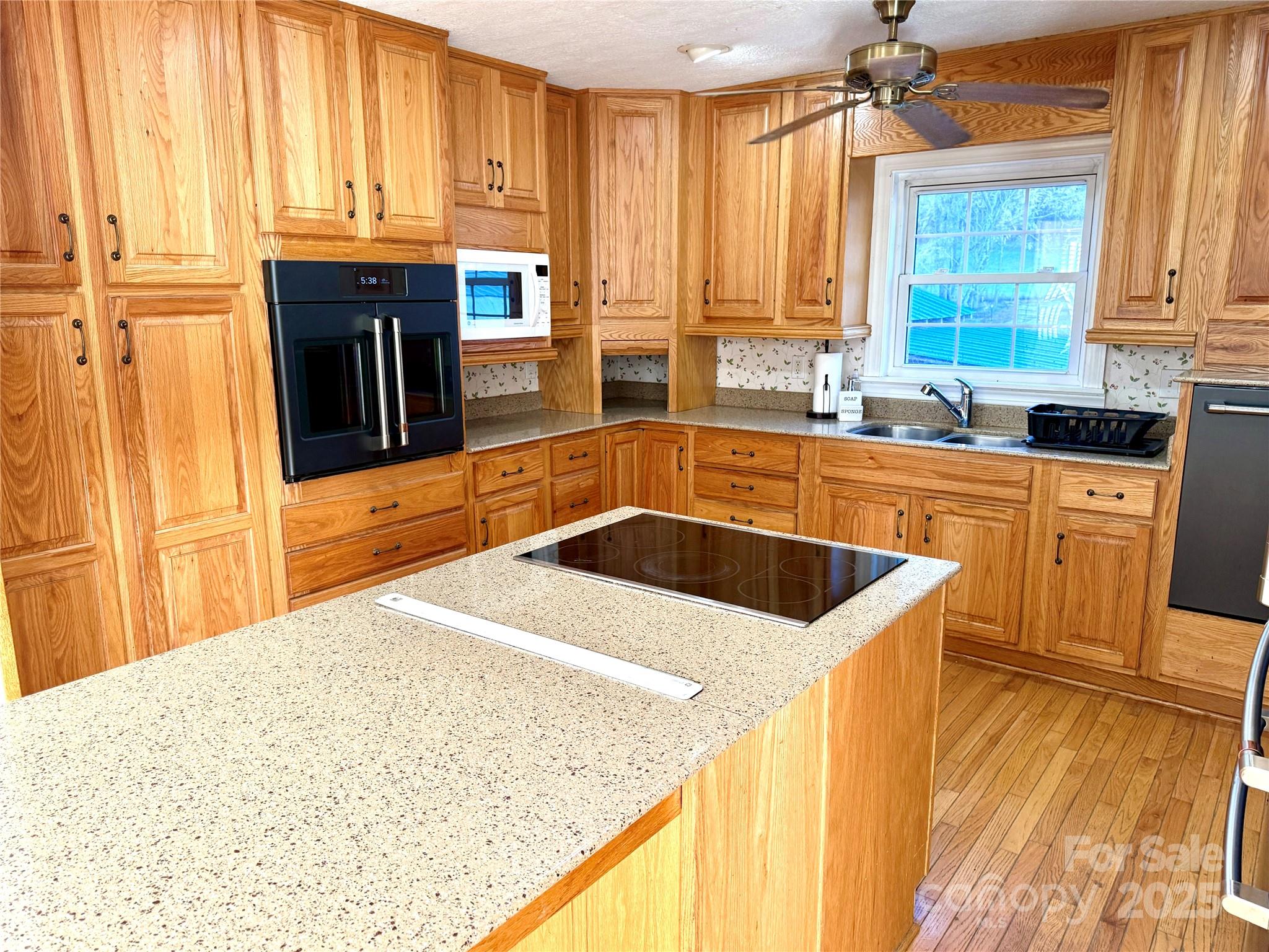 718 Bald Mountain Road Burnsville, NC 28714 - Photo 4 of 37 a kitchen with granite countertop a sink a counter top space and cabinets