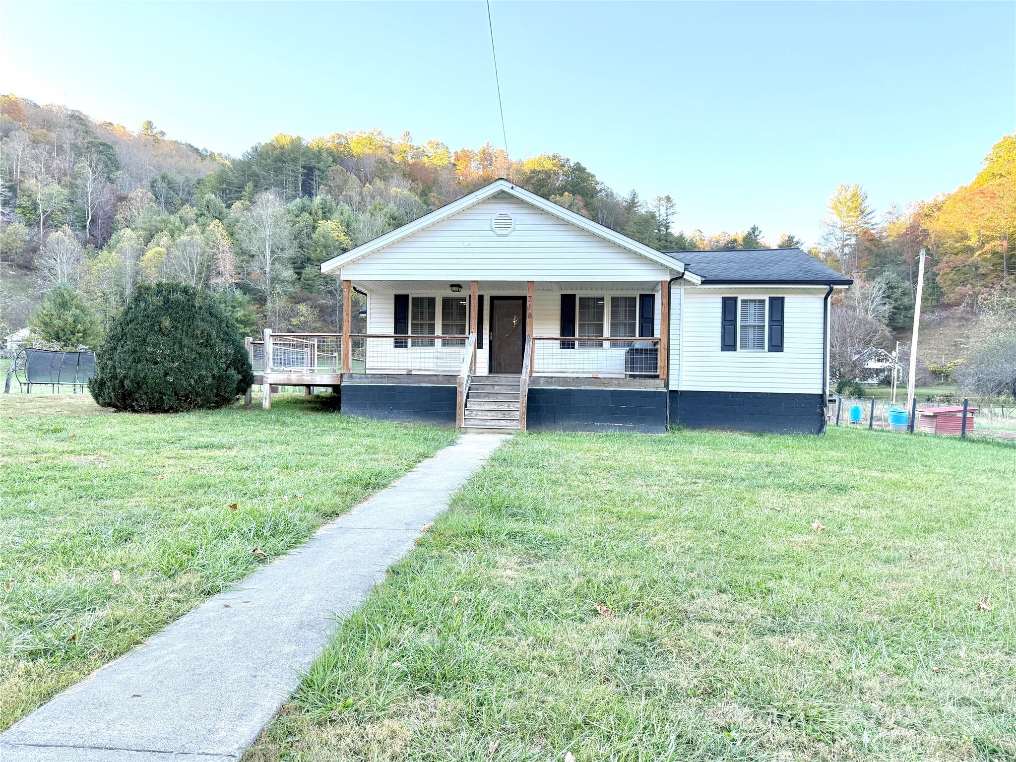 718 Bald Mountain Road Burnsville, NC 28714 - Photo 6 of 37 a front view of a house with a garden and yard