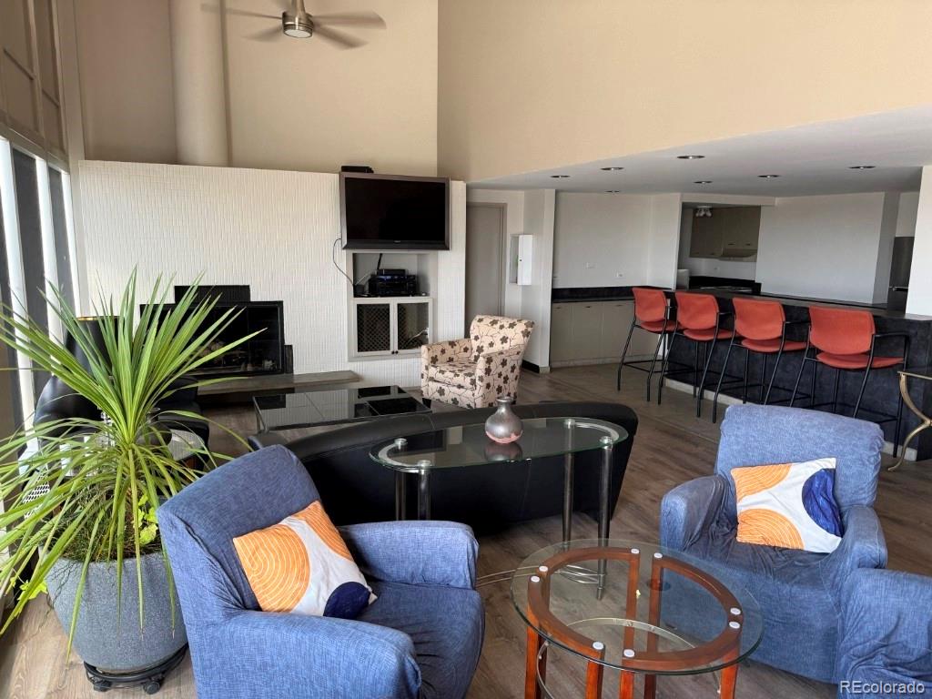 888 Logan Street, Unit 5H Denver, CO 80203 - Photo 21 of 25 a living room with furniture potted plant and a fireplace