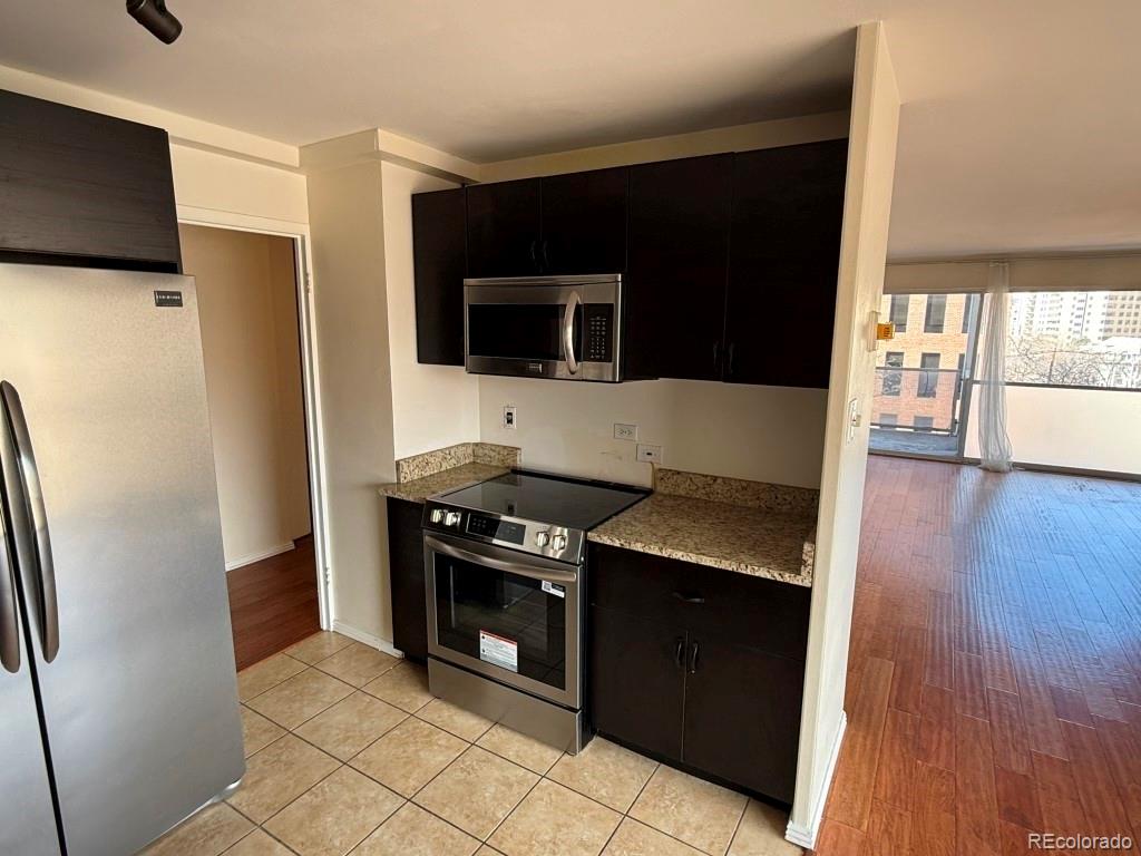 888 Logan Street, Unit 5H Denver, CO 80203 - Photo 7 of 25 a kitchen with a stove microwave and refrigerator