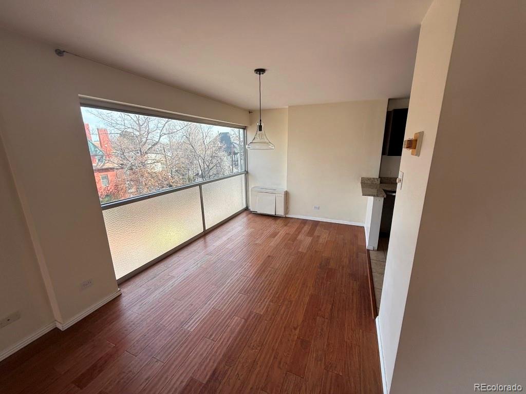 888 Logan Street, Unit 5H Denver, CO 80203 - Photo 9 of 25 wooden floor in an empty room with a window