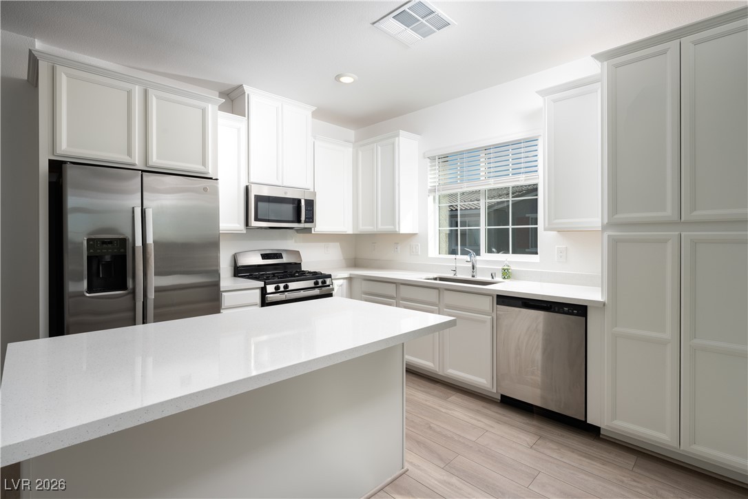 7330 North Decatur Boulevard, Unit 1 North Las Vegas, NV 89084 - Photo 11 of 29 Kitchen with stainless steel appliances, white cabinets, light stone counters, recessed lighting, and light wood-type flooring