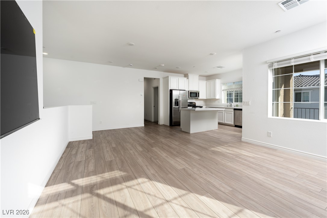7330 North Decatur Boulevard, Unit 1 North Las Vegas, NV 89084 - Photo 12 of 29 Unfurnished living room featuring light wood finished floors and baseboards