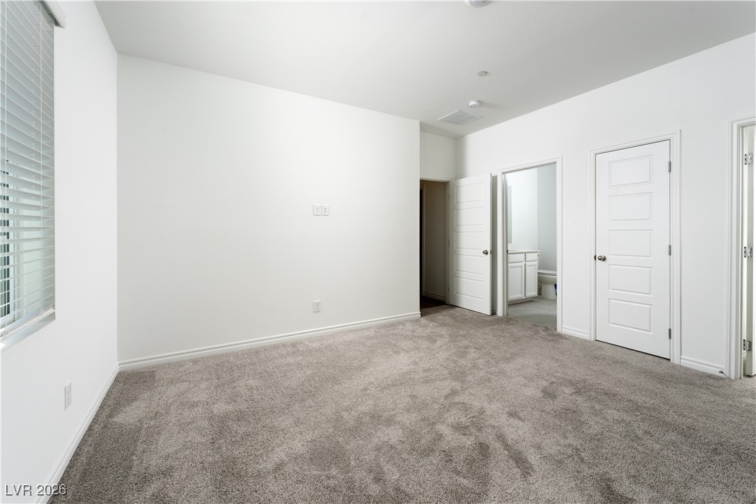 7330 North Decatur Boulevard, Unit 1 North Las Vegas, NV 89084 - Photo 15 of 29 Unfurnished bedroom featuring carpet flooring and ensuite bathroom