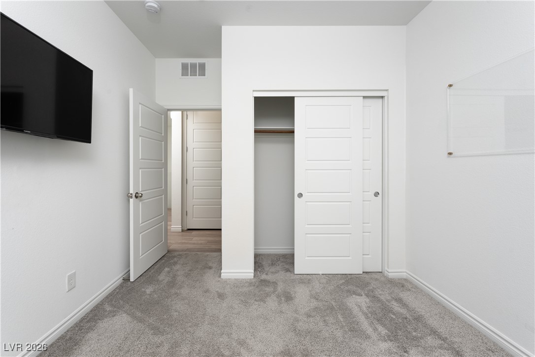 7330 North Decatur Boulevard, Unit 1 North Las Vegas, NV 89084 - Photo 20 of 29 Unfurnished bedroom with light colored carpet and a closet