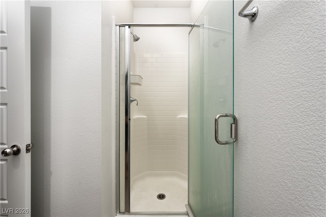 7330 North Decatur Boulevard, Unit 1 North Las Vegas, NV 89084 - Photo 23 of 29 Full bath featuring a textured wall and a shower stall