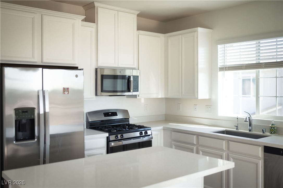 7330 North Decatur Boulevard, Unit 1 North Las Vegas, NV 89084 - Photo 5 of 29 Kitchen with stainless steel appliances, white cabinetry, and light stone countertops