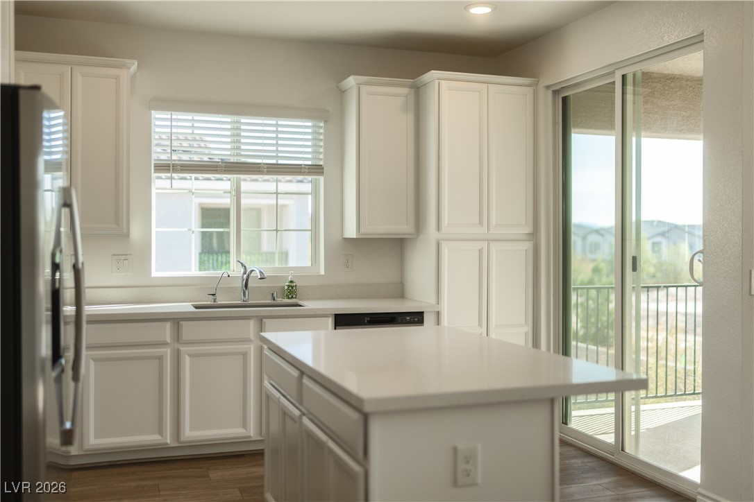 7330 North Decatur Boulevard, Unit 1 North Las Vegas, NV 89084 - Photo 6 of 29 Kitchen featuring fridge with ice dispenser, white cabinets, dark wood-style floors, and a kitchen island