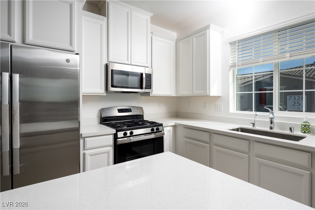 7330 North Decatur Boulevard, Unit 1 North Las Vegas, NV 89084 - Photo 9 of 29 Kitchen featuring stainless steel appliances, white cabinets, and light stone counters