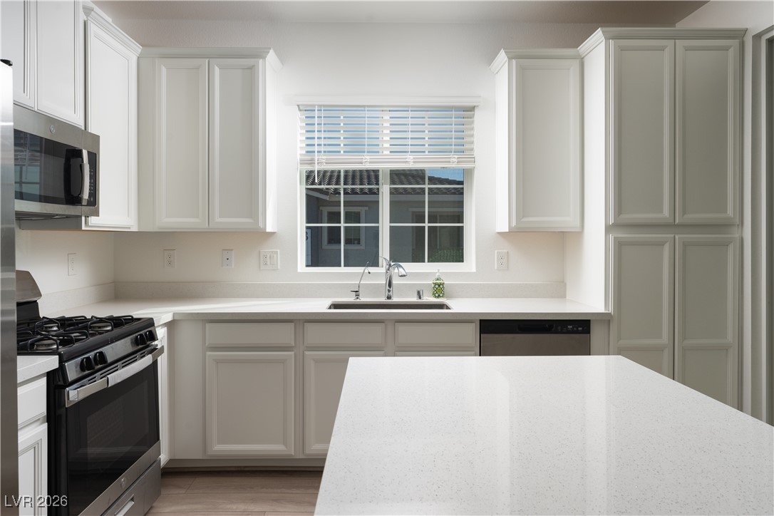 7330 North Decatur Boulevard, Unit 1 North Las Vegas, NV 89084 - Photo 10 of 29 Kitchen featuring stainless steel appliances, white cabinetry, and light stone counters