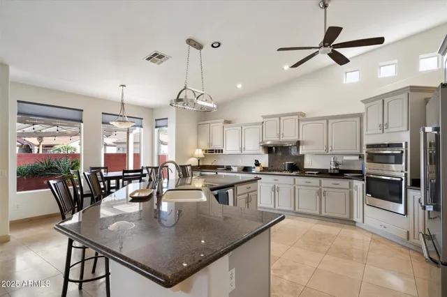 a bedroom with a bed a couch and a chandelier