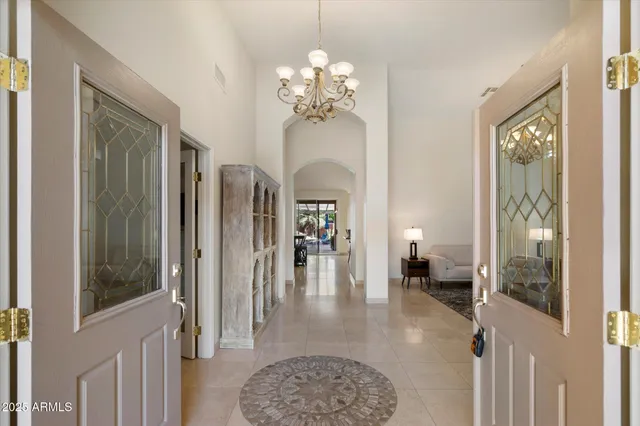 a living room with furniture a chandelier and a window