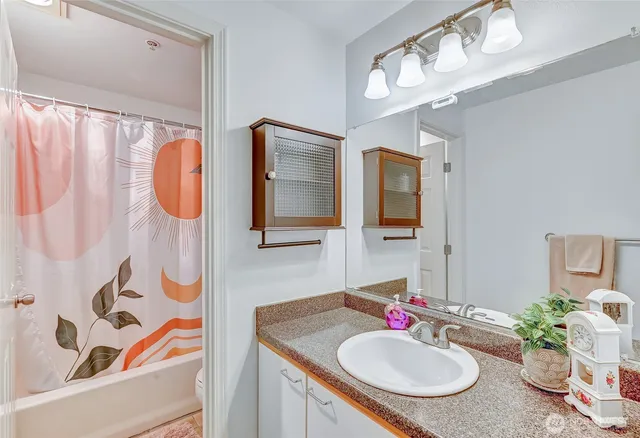 a bedroom with a bed and potted plant on the dresser