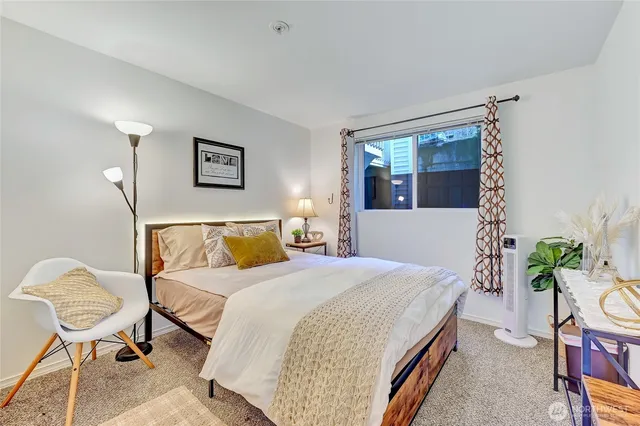 a bedroom with a bed and painting on the wall