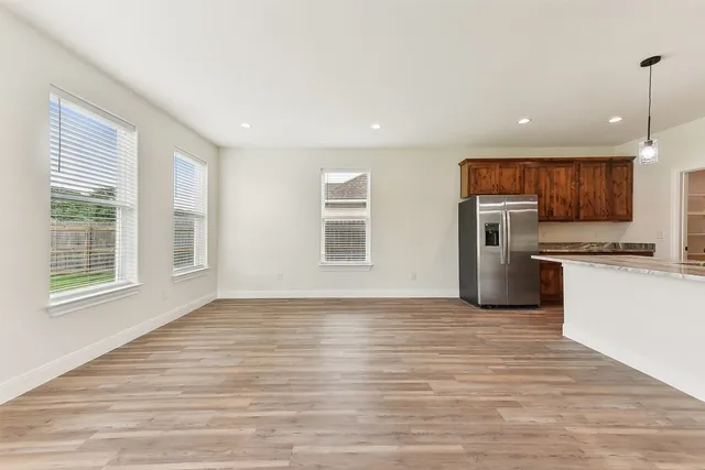 a view of kitchen with refrigerator microwave and stove with wooden floor