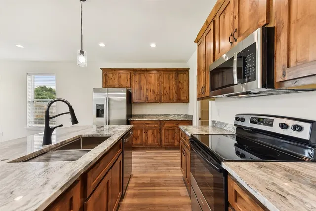 a kitchen with stainless steel appliances granite countertop a sink and a stove