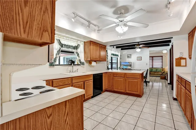 a kitchen with a stove a sink dishwasher and a refrigerator with wooden cabinets