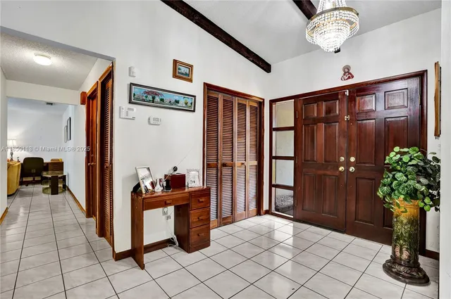 a bed sitting in a bedroom next to a window with a chandelier