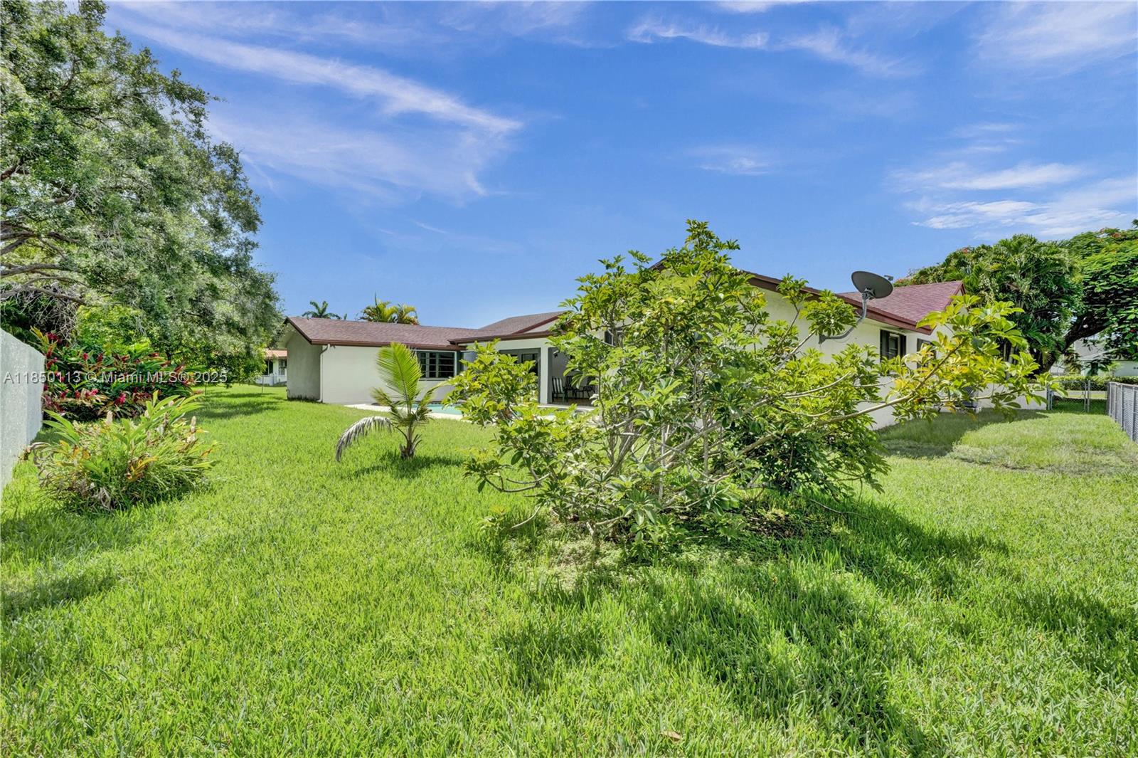 9461 Southwest 134th Street Miami, FL 33176 - Photo 32 of 33 a backyard of a house with lots of green space and garden view