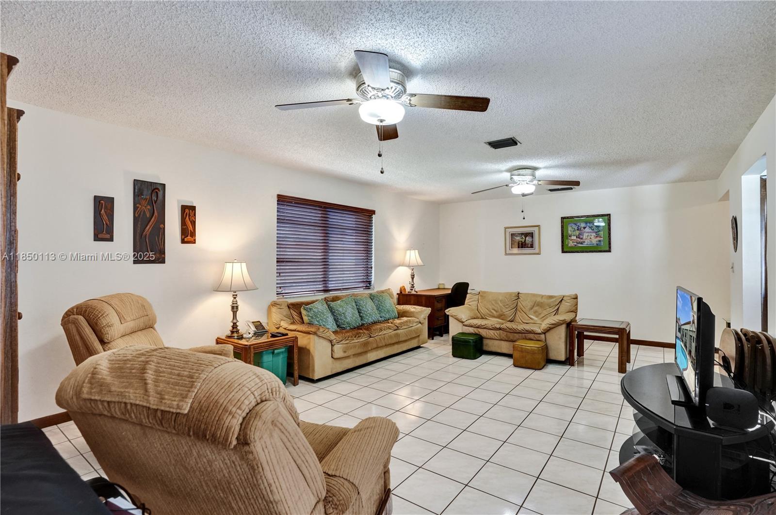 9461 Southwest 134th Street Miami, FL 33176 - Photo 10 of 33 a living room with furniture and a flat screen tv
