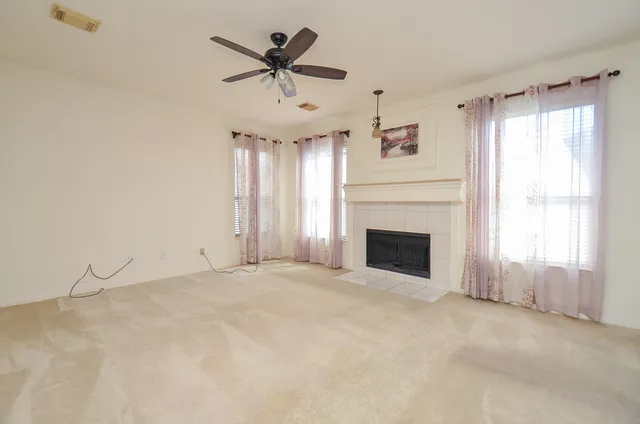 a view of an empty room with a fireplace and a window