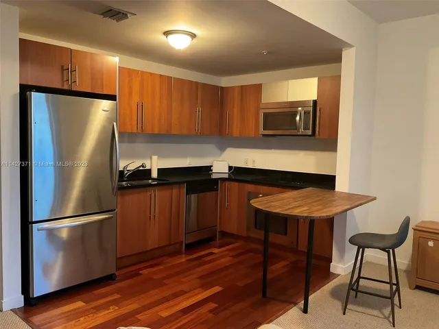 a kitchen with stainless steel appliances a refrigerator a stove a sink and a microwave
