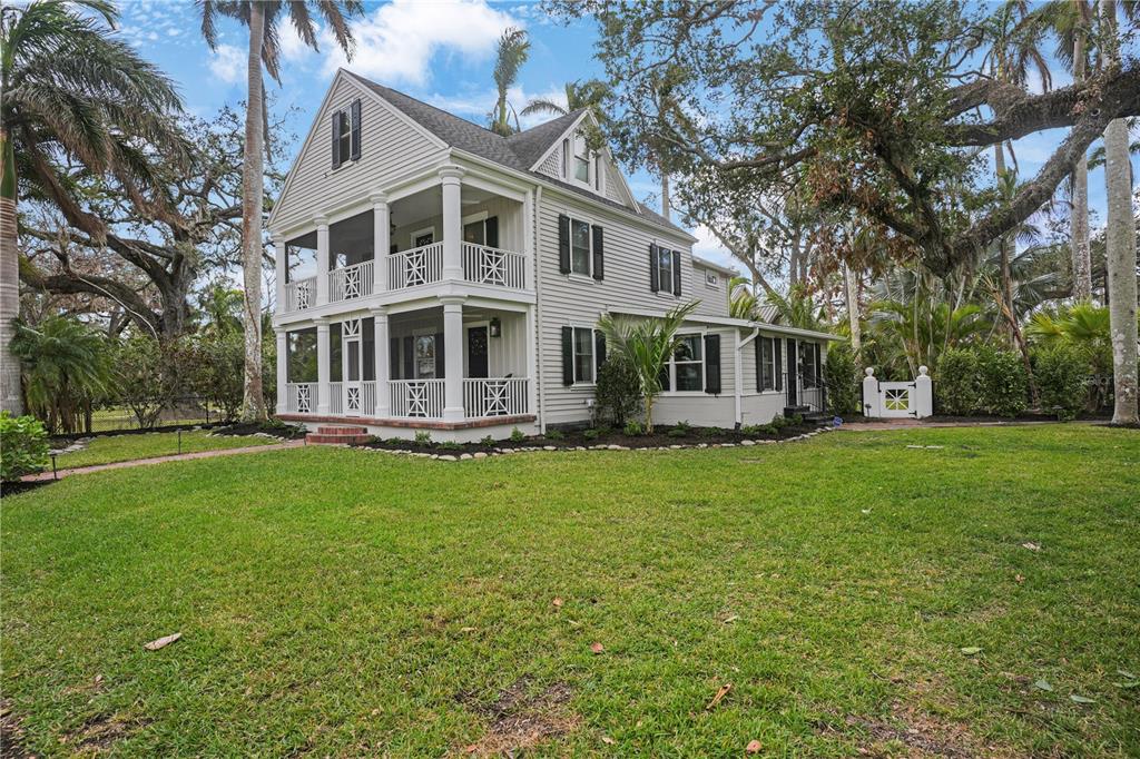 a front view of a house with a garden and trees