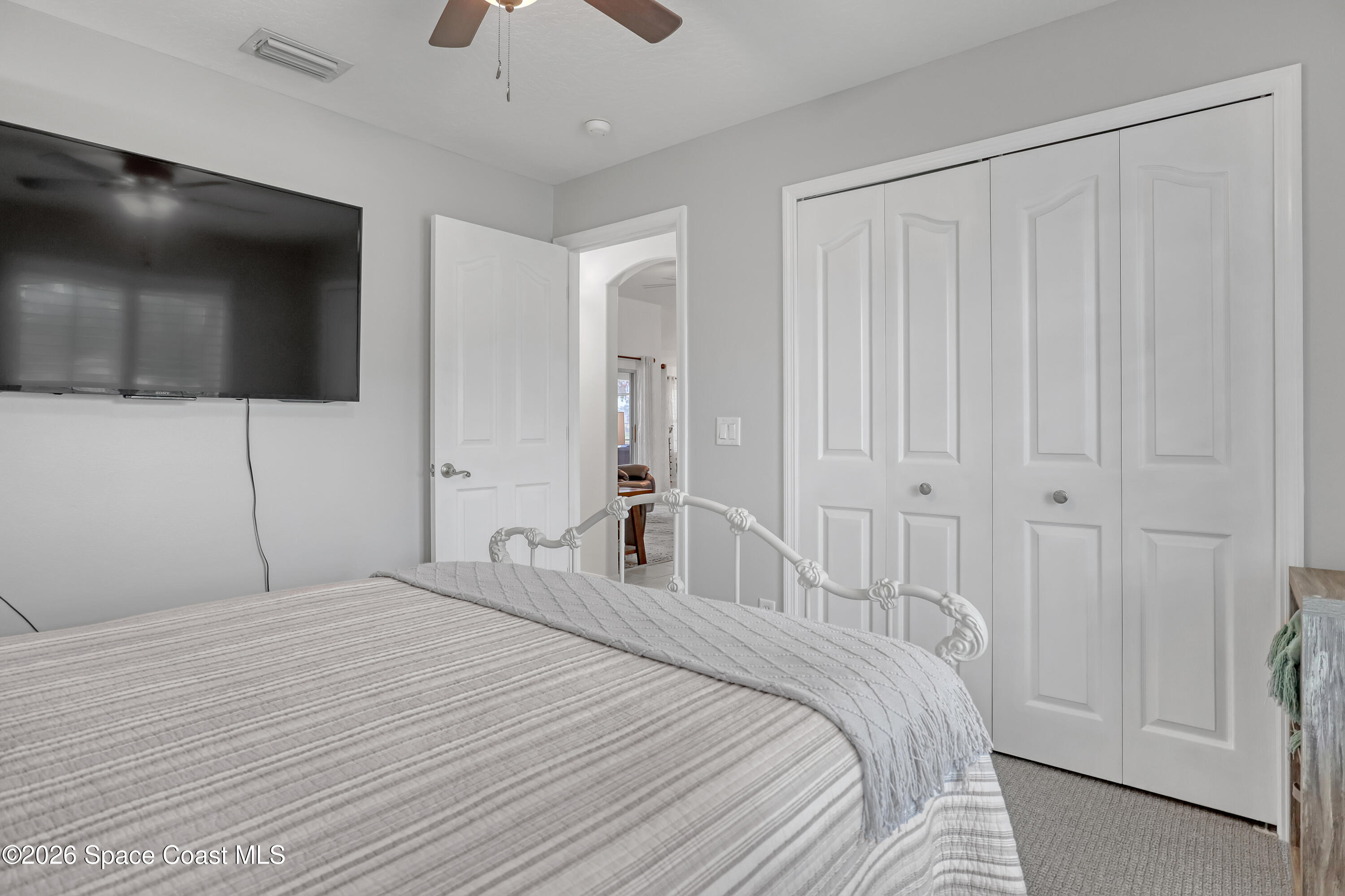 3120 Forest Creek Drive Melbourne, FL 32901 - Photo 32 of 59 a bedroom with a bed and a flat tv screen