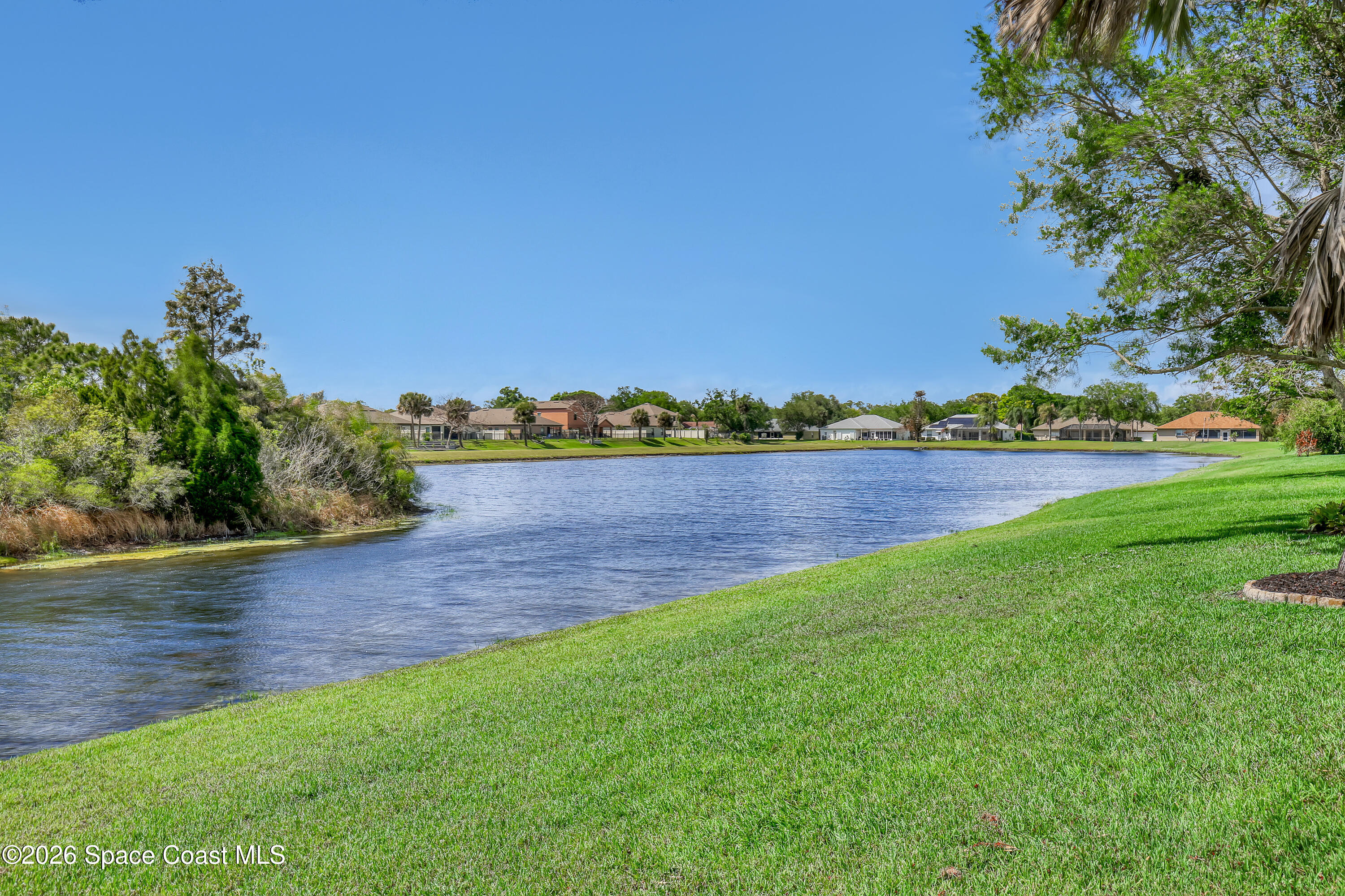 3120 Forest Creek Drive Melbourne, FL 32901 - Photo 51 of 59 a view of a lake with houses in the back