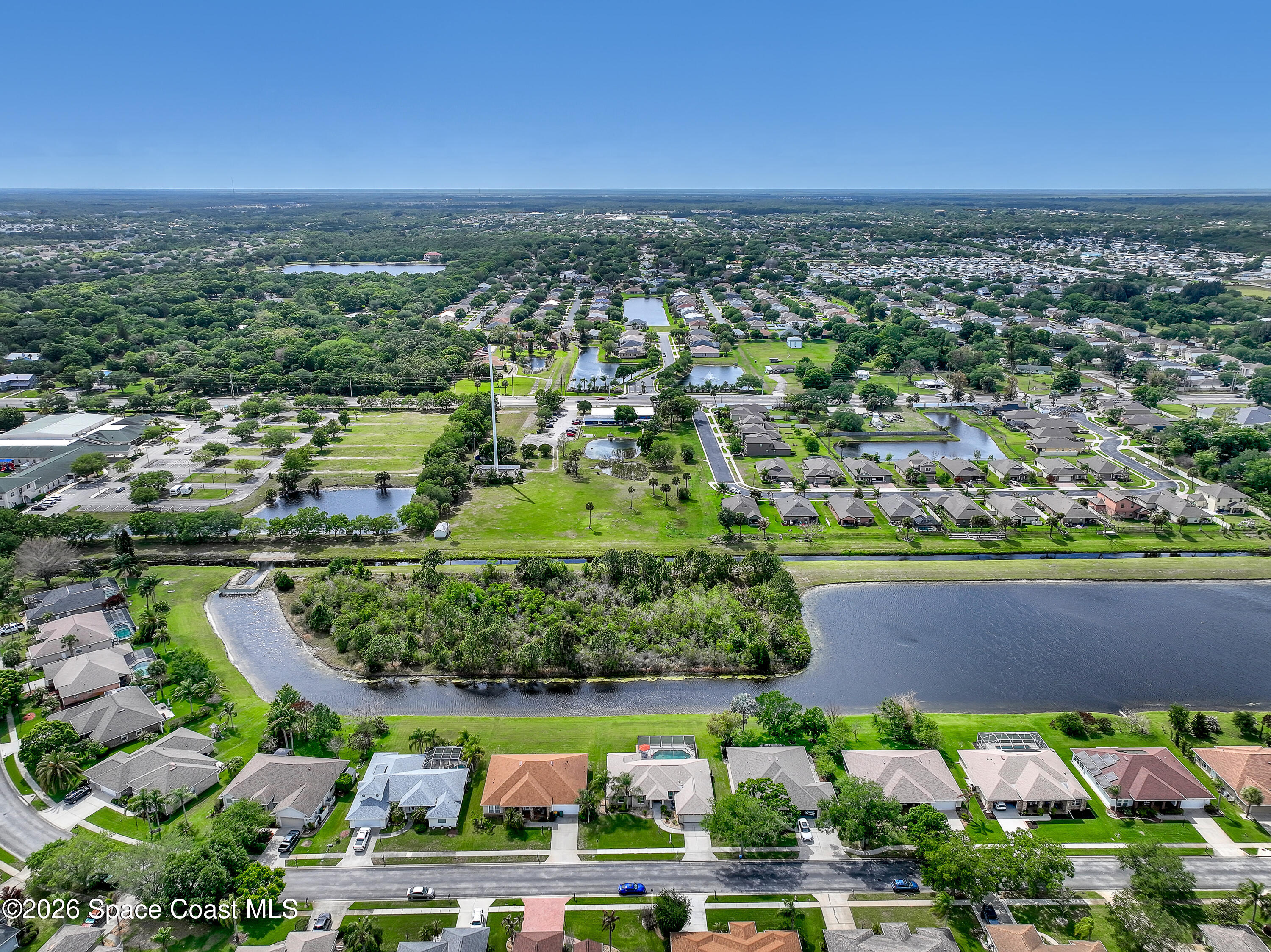 3120 Forest Creek Drive Melbourne, FL 32901 - Photo 52 of 59 an aerial view of a city with lots of residential buildings ocean and mountain view in back