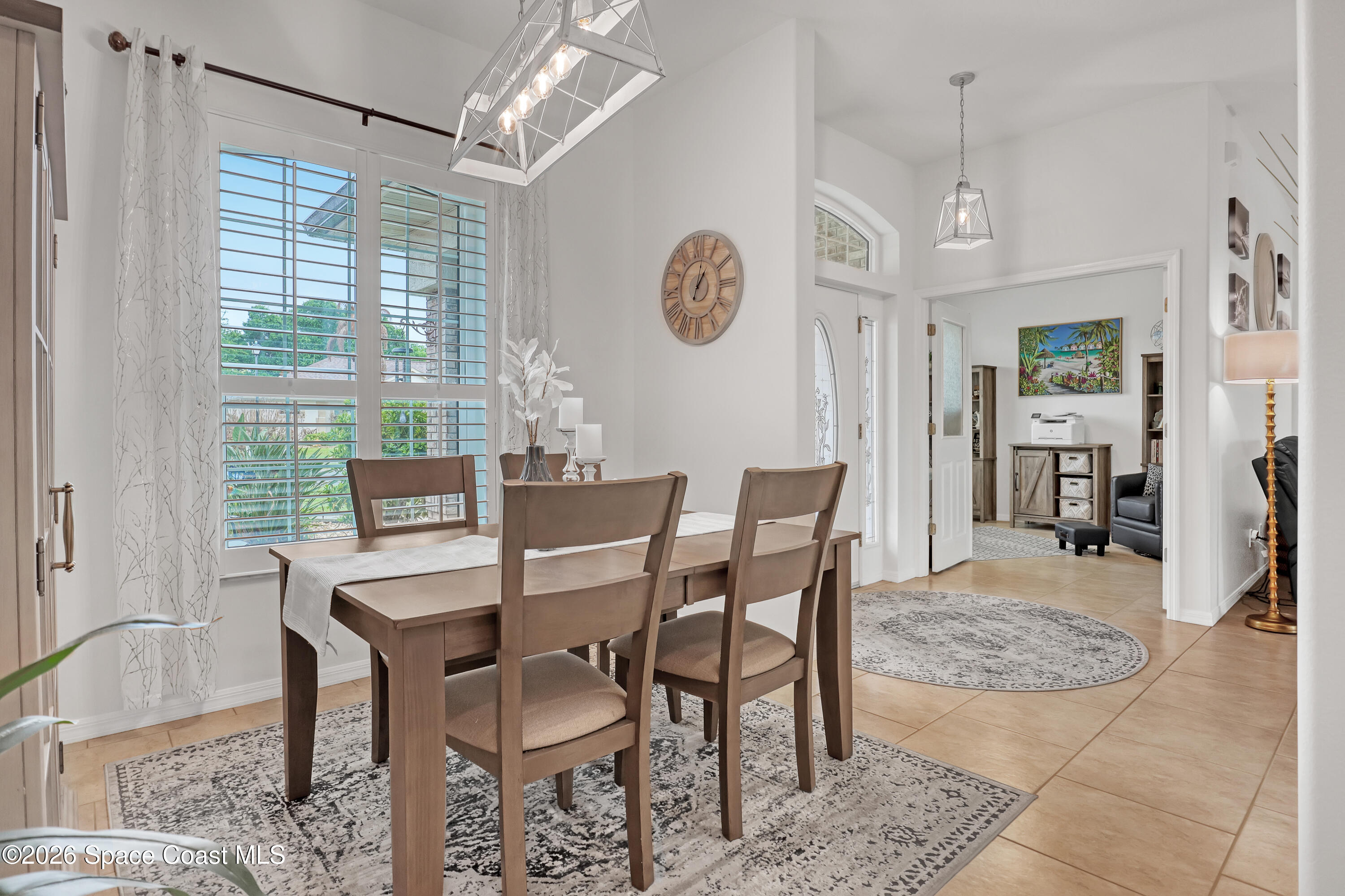 3120 Forest Creek Drive Melbourne, FL 32901 - Photo 10 of 59 a dining room with wooden floor and a chandelier