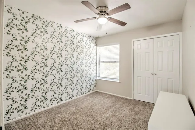 a view of empty room with window and ceiling fan