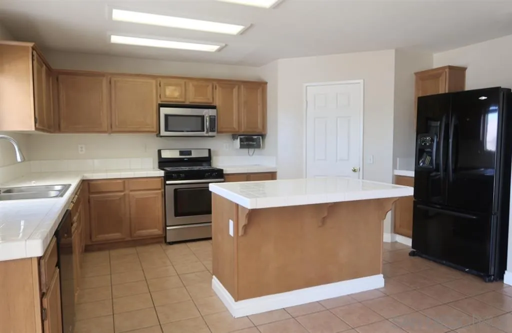 33734 Abbey Road Temecula, CA 92592 - Photo 21 of 25 a kitchen with a sink a stove and refrigerator