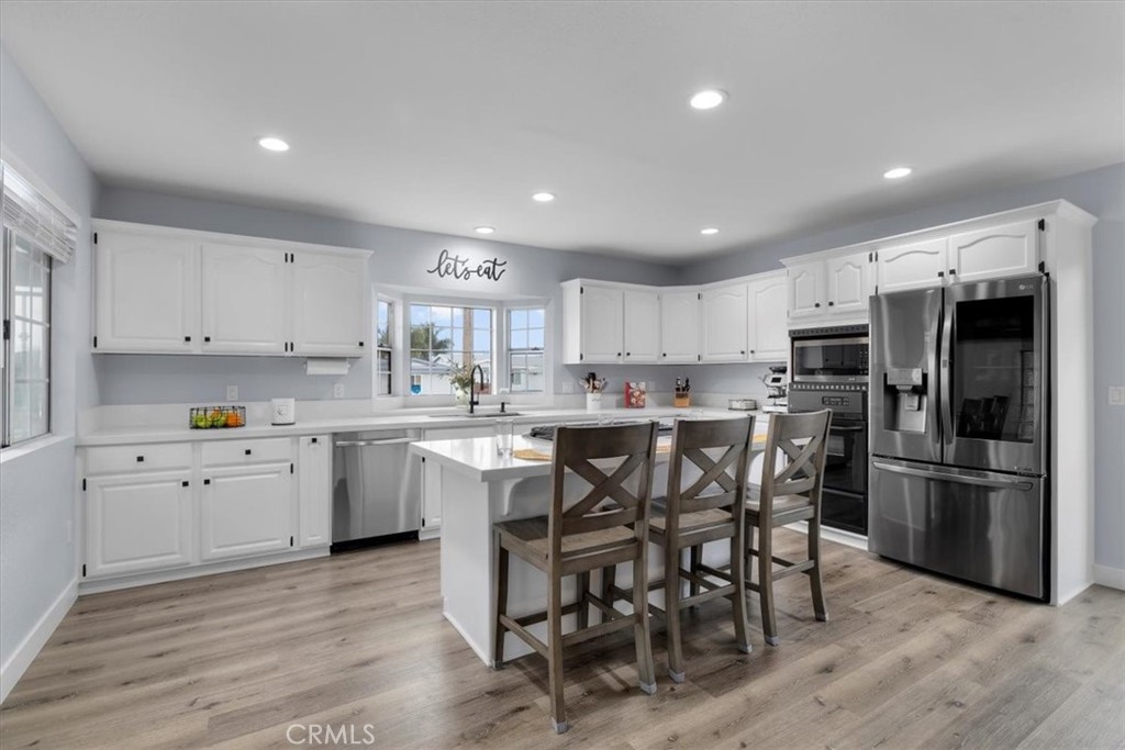 338 East 219th Street Carson, CA 90745 - Photo 5 of 36 a kitchen with stainless steel appliances granite countertop a white table chairs and microwave