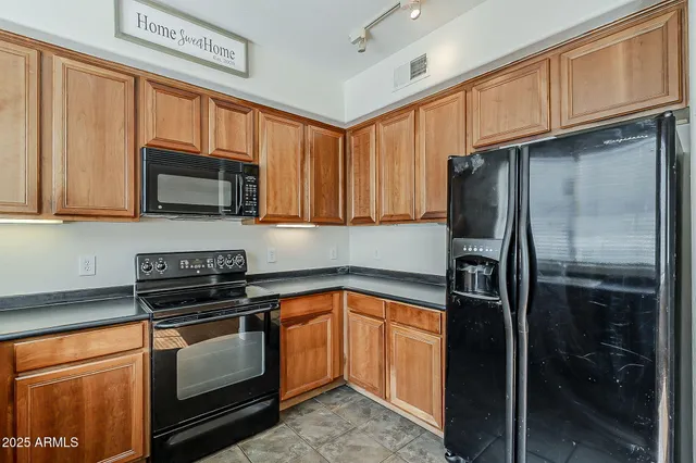 an empty room with wooden floor chandelier fan and windows